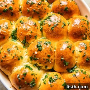 top down view of dinner rolls brushed with melted herb and garlic butter