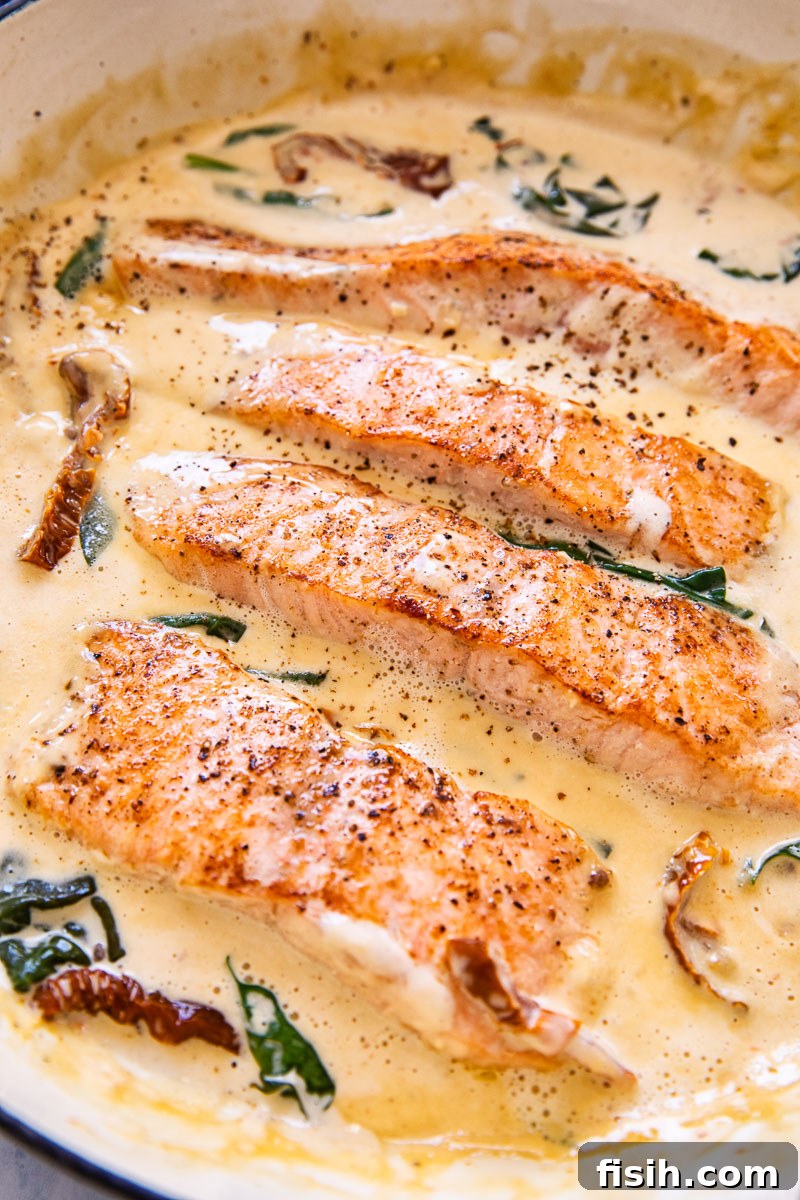 salmon in cream sauce with sun-dried tomatoes and spinach