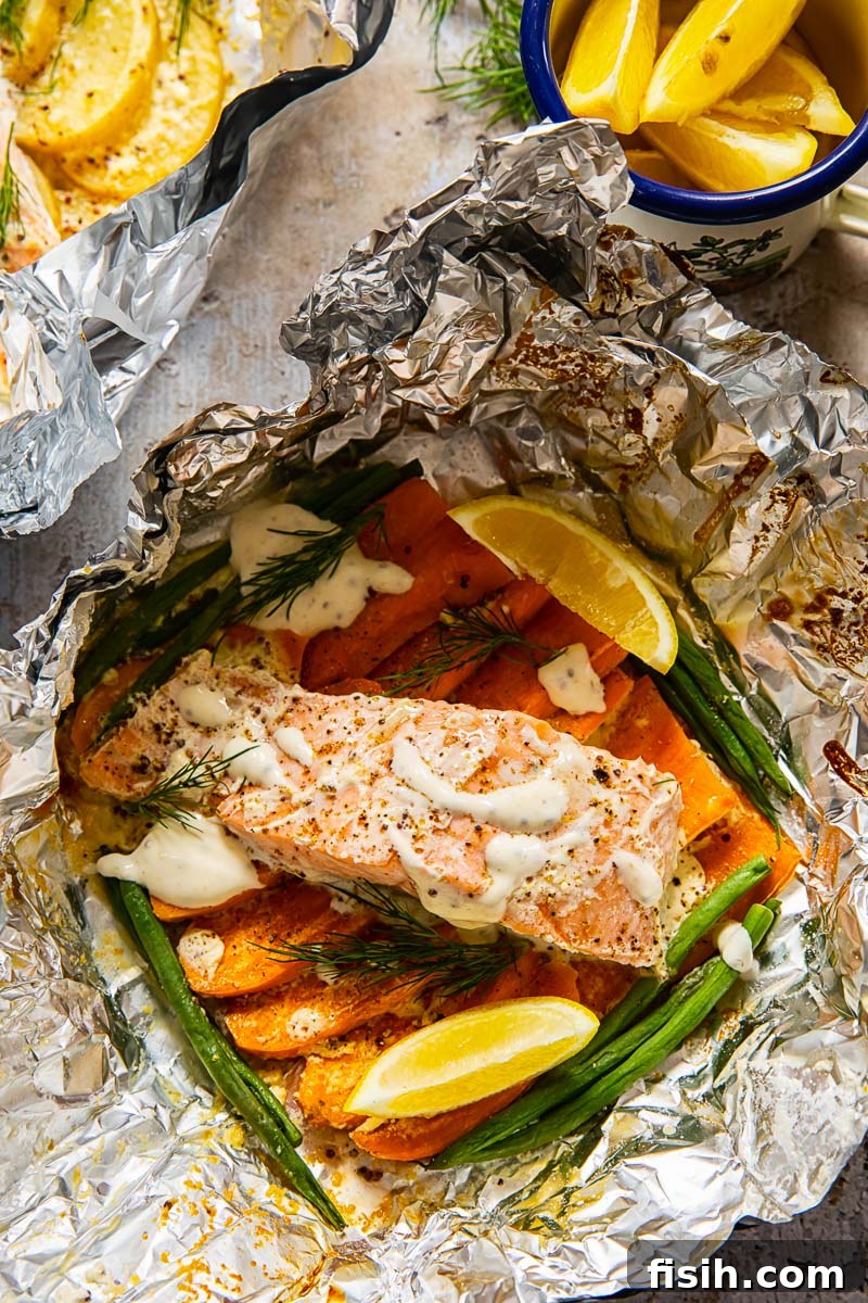 Campfire Salmon and Potato Foil Packs 3 salmon on top of sweet potatoes and green beans in a foil packet ready for cooking