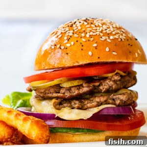 Side view of a perfectly stacked smash burger with fresh toppings