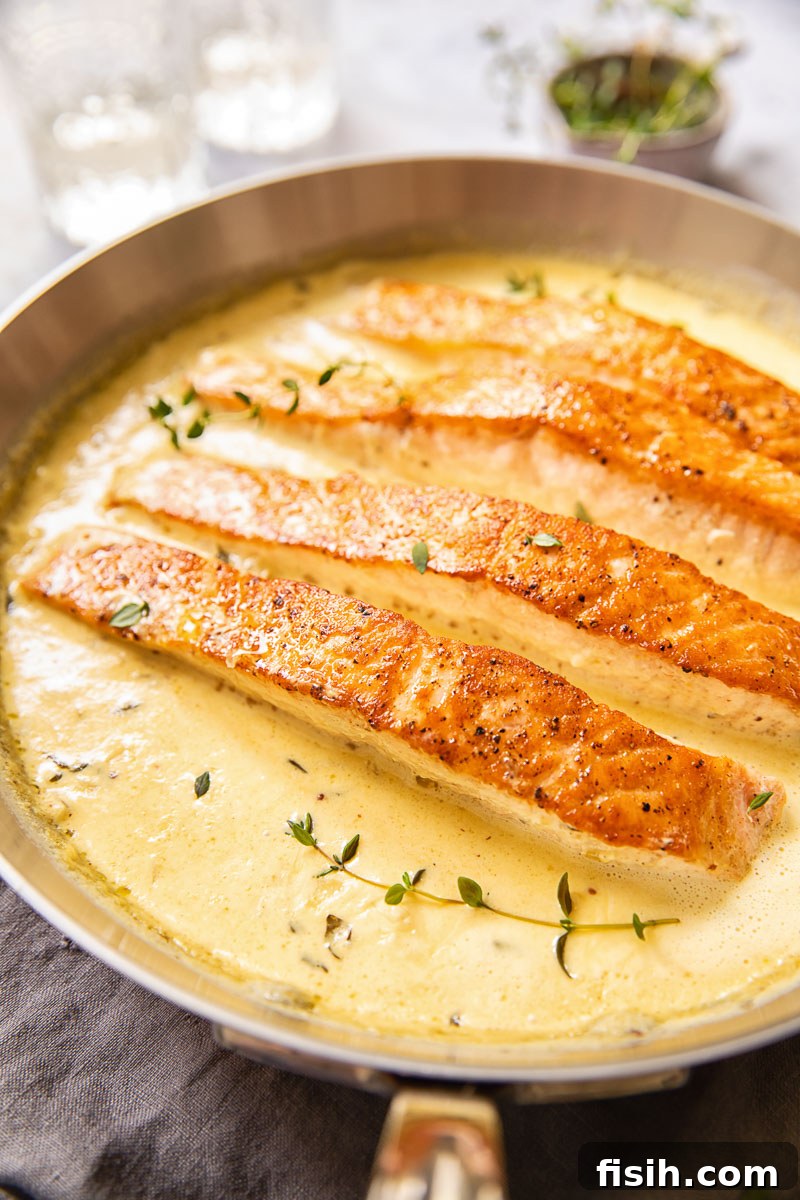 Pan-Seared Salmon with Tangy Creamy Mustard 5 Salmon fillets nestled in creamy mustard sauce within a pan.