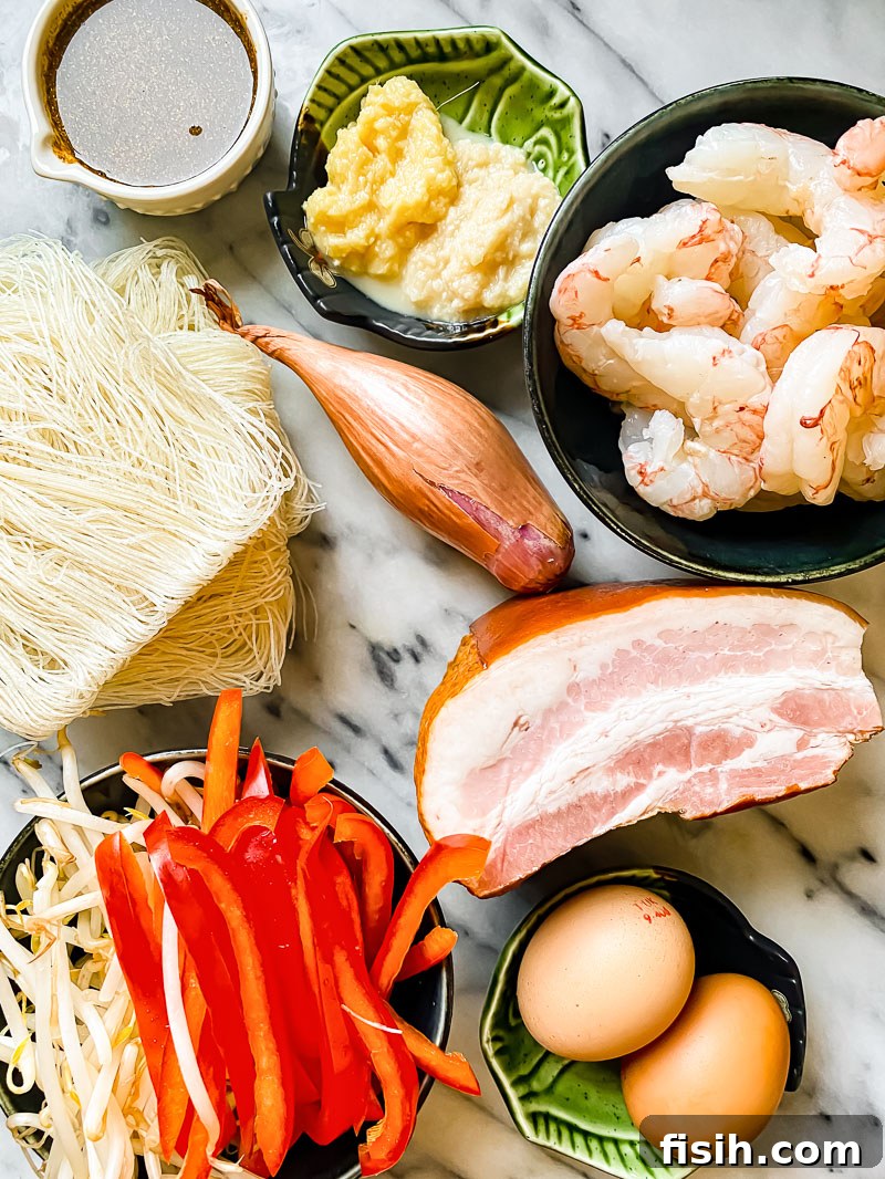 Assortment of fresh ingredients for Singapore Noodles laid out on a marble board, including prawns, pork, noodles, vegetables, and spices