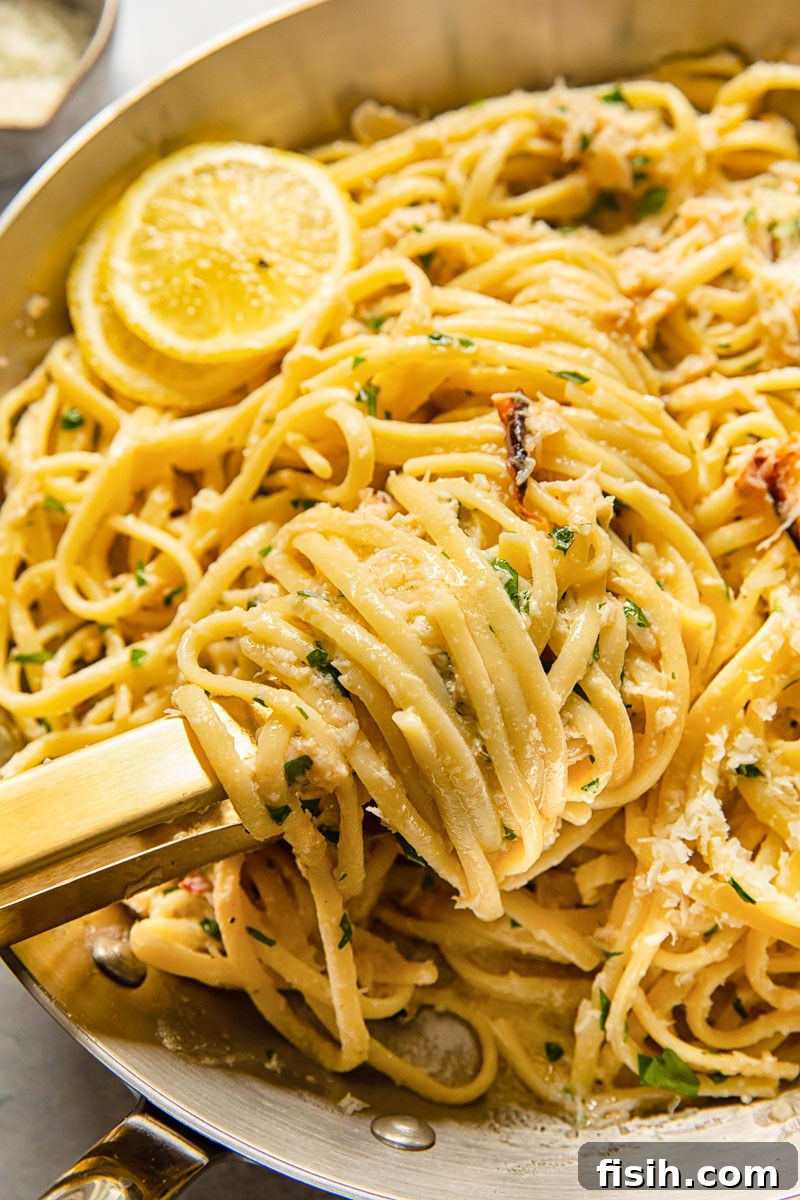 Close-up of delicious crab pasta being tossed in a pan, showcasing the rich lemon butter sauce and tender crab flakes.