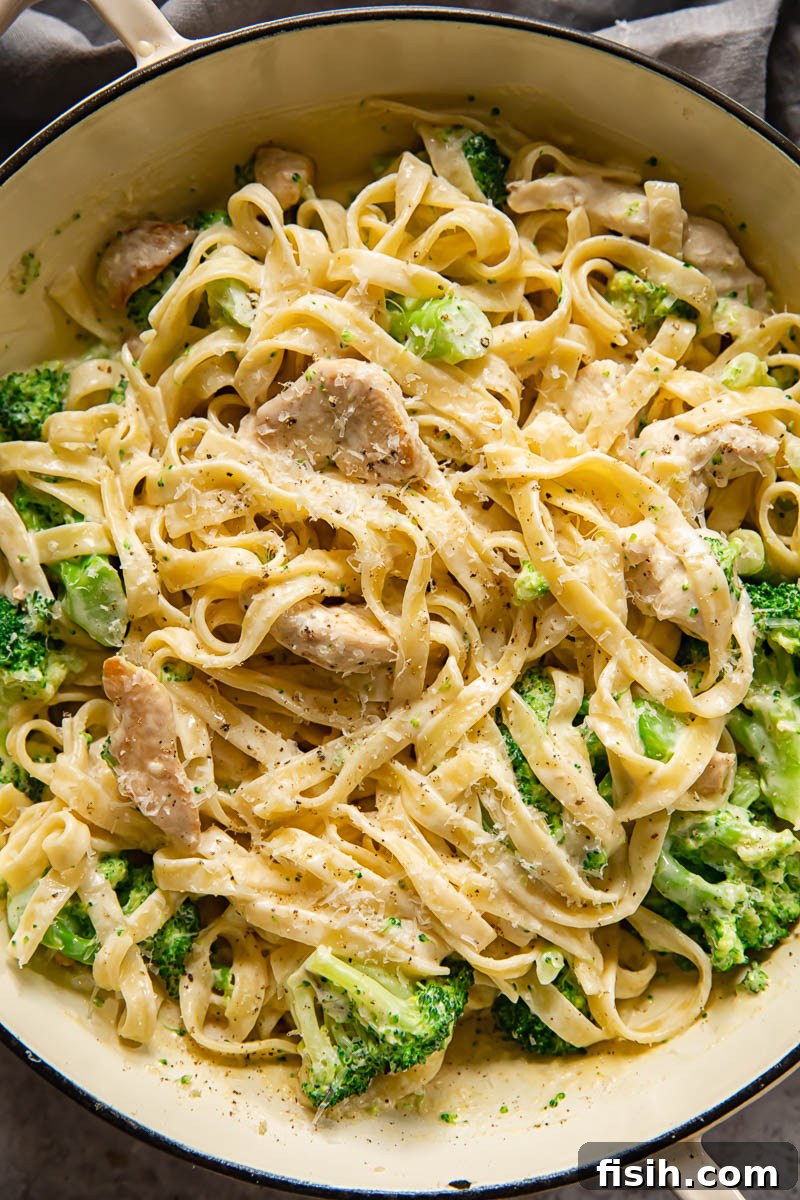 top down view of chicken broccoli alfredo pasta, garnished with fresh parsley