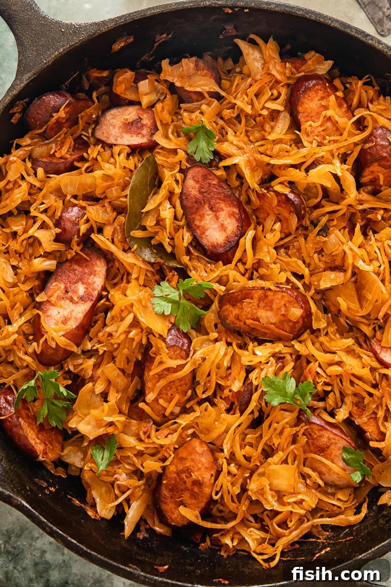 Savory Kielbasa with Tangy Sauerkraut 2 Smoky kielbasa and tangy sauerkraut braised with apples and tomatoes in a frying pan