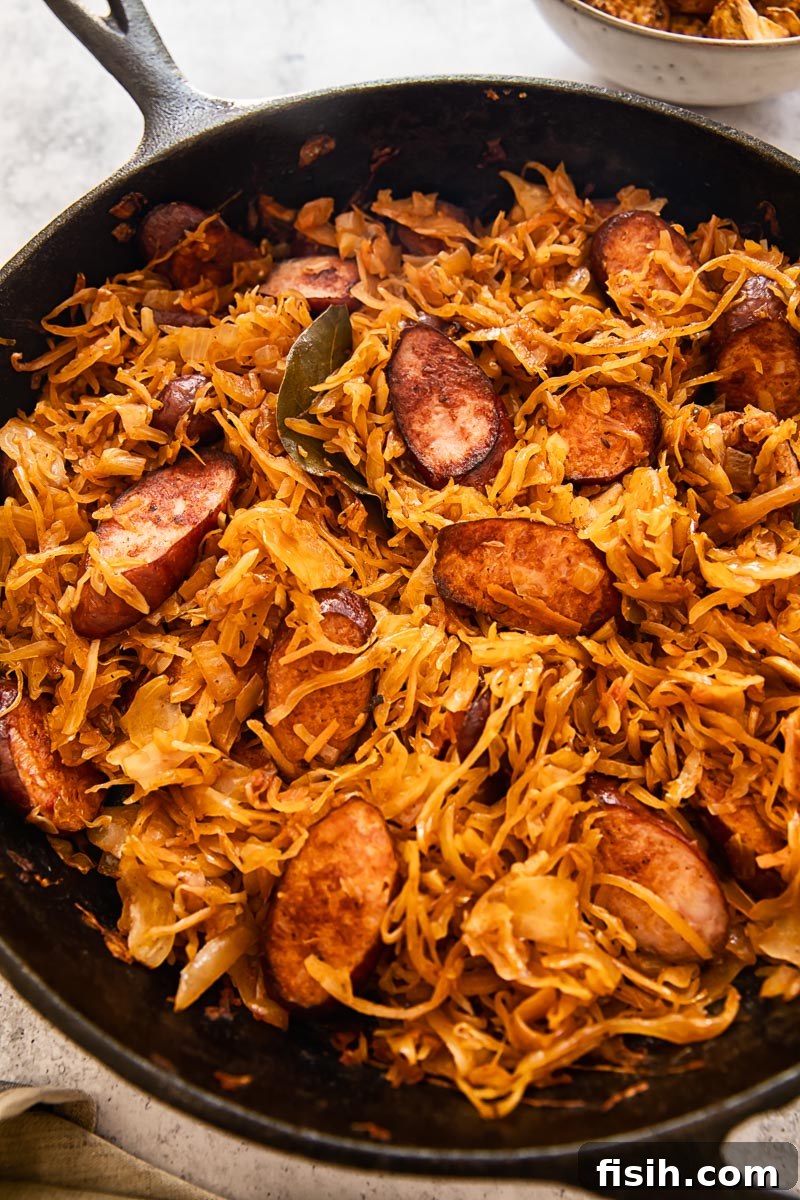Savory Kielbasa with Tangy Sauerkraut 4 braised sauerkraut with tomatoes and kielbasa in a skillet, ready to be served