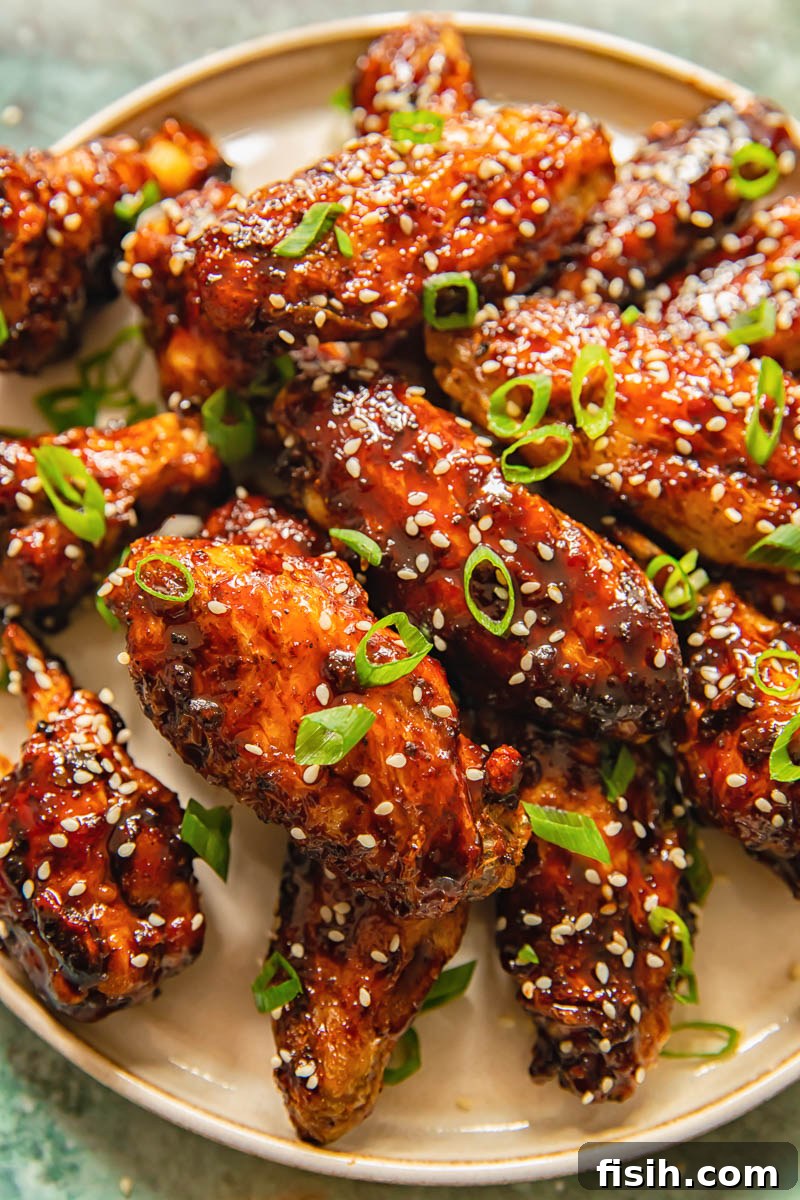 Crispy chicken wings glazed with sticky Asian sauce on a white plate