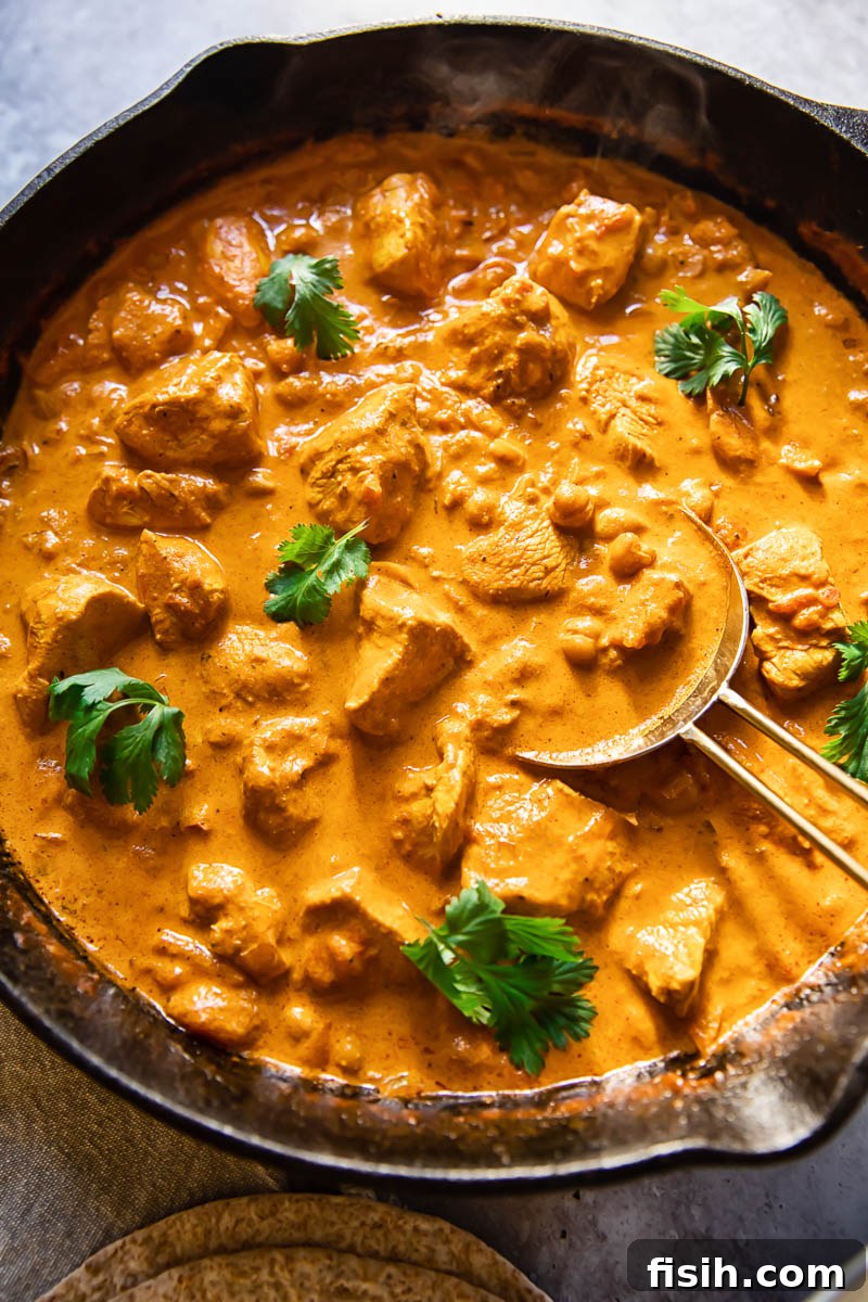 Rich and Creamy Chicken Tikka Masala 2 Top-down view of creamy homemade Chicken Tikka Masala in a pan, garnished with fresh cilantro, ready to be served.