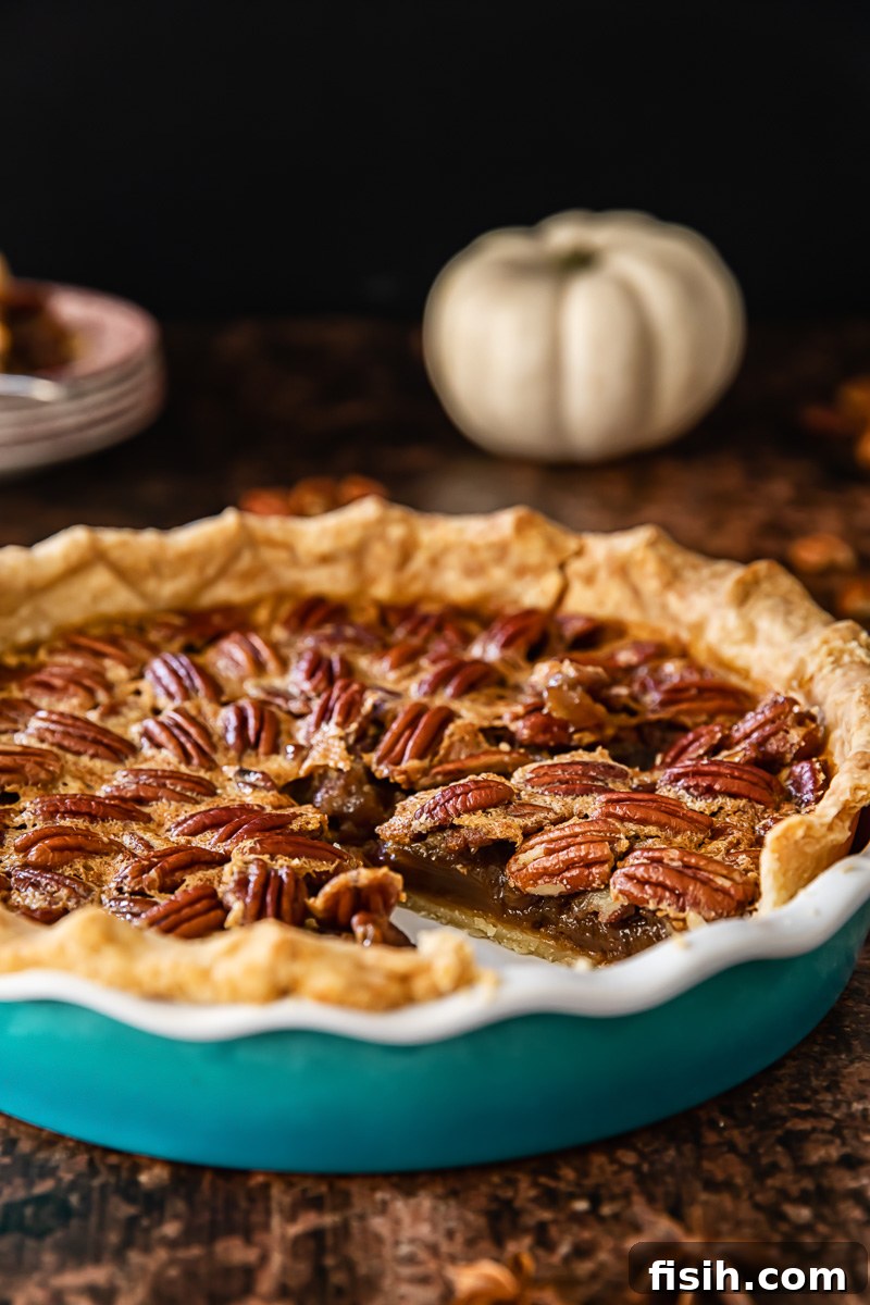 Spiked Maple Pecan Perfection 7 A side profile view of a fully baked Maple Bourbon Pecan Pie in a ceramic pie dish, highlighting its impressive height, glistening top, and golden crust.