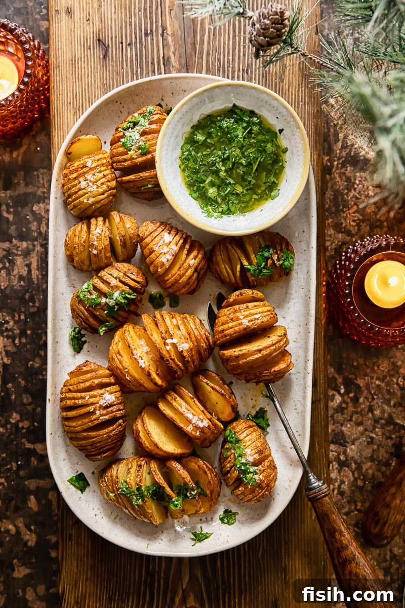 top down view of a platter with roasted potatoes set over a wooden serving board, two candles on the table