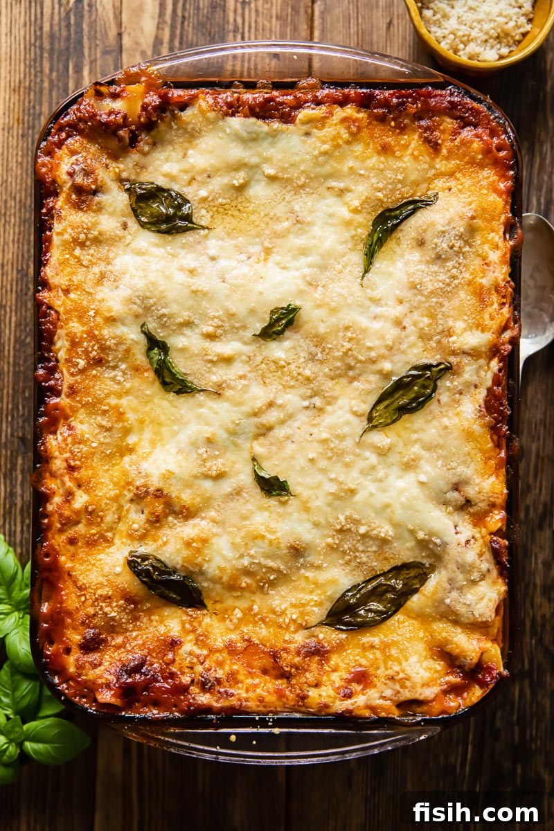 An uncut pan of traditional Italian lasagne, freshly baked with a golden-brown and bubbly top, ready to be sliced and served, highlighting the deep comfort food appeal.