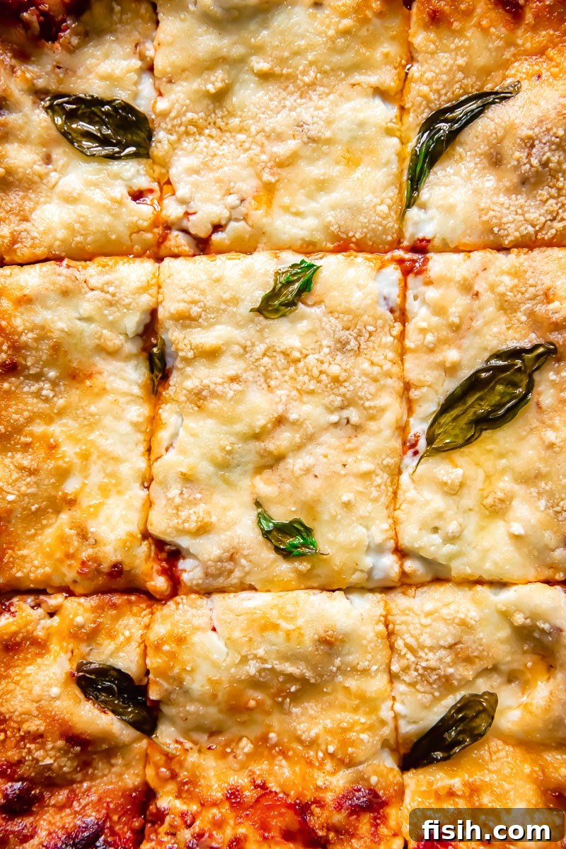 A close-up view of individual squares of classic lasagne, showing the beautifully distinct layers of pasta, rich Bolognese, and creamy Béchamel with a golden, bubbly cheese top.