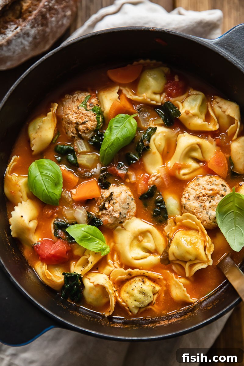 Hearty chicken meatball tortellini soup simmering in a large pot, ready to be served, capturing the warmth and inviting aroma of a homemade meal.
