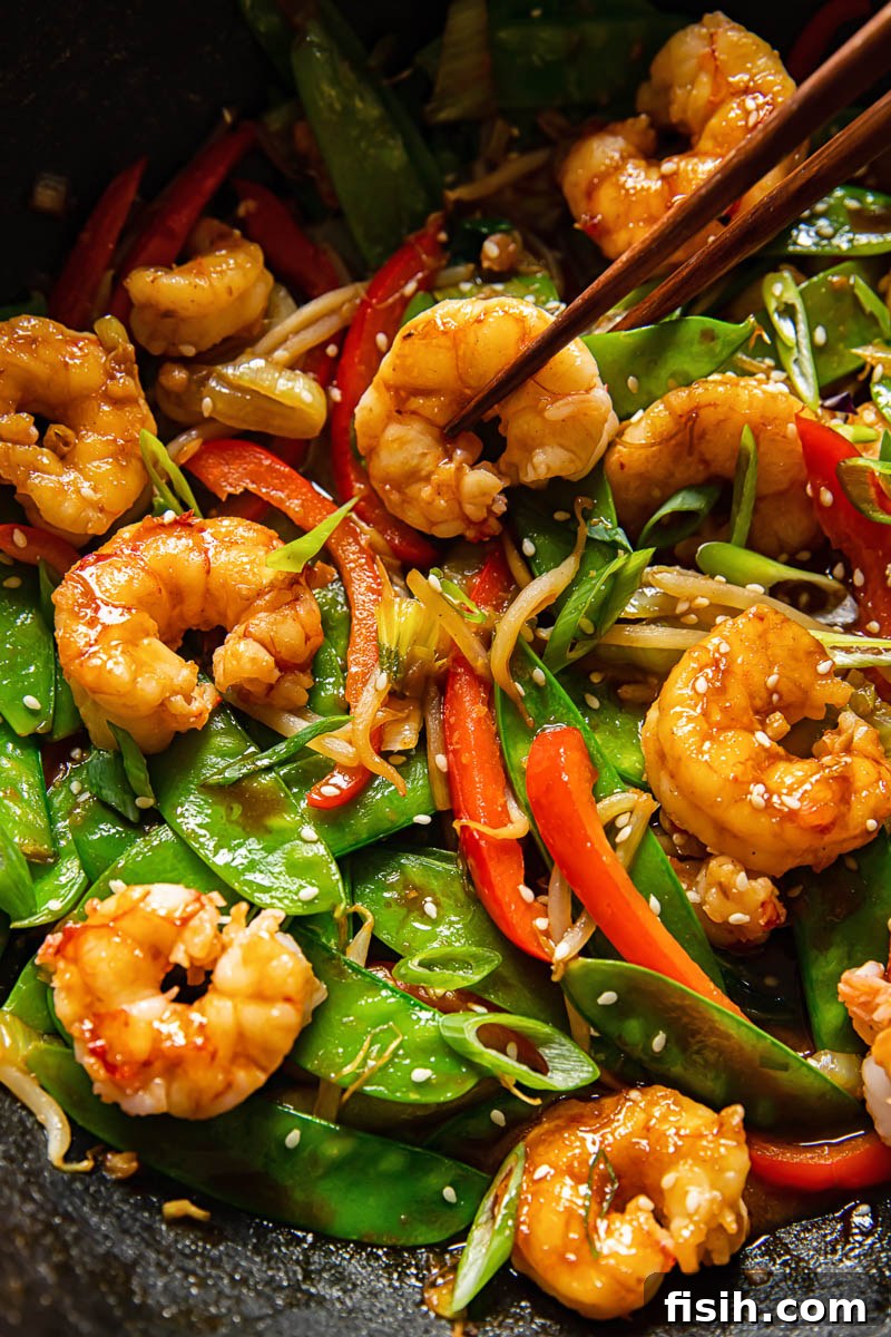 close up of prawn and vegetable stir fry in a wok, showcasing succulent shrimp and colorful vegetables coated in sauce