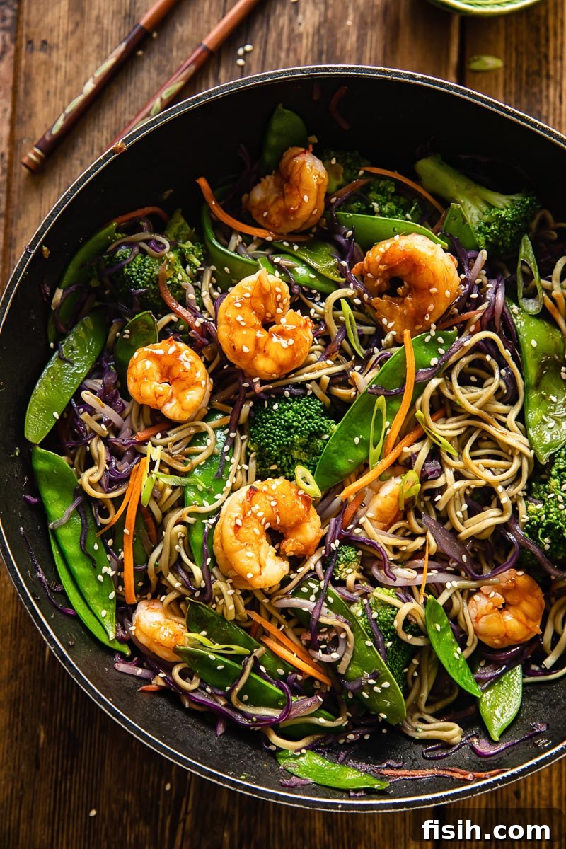 Sizzling Prawn Noodle Stir-Fry 2 A vibrant top-down view of a delicious Prawn Noodle Stir Fry in a wok, rich with vegetables and plump prawns.