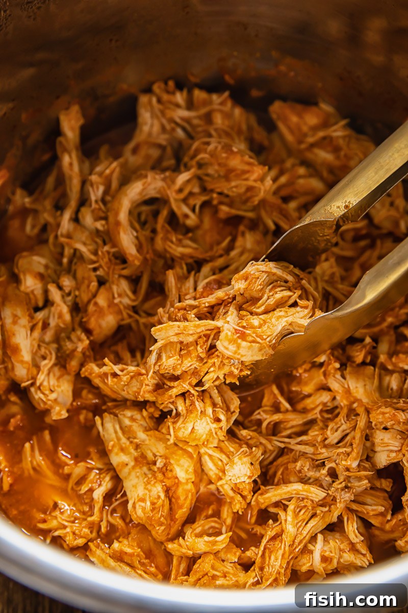 Lightning Fast Instant Pot Shredded Chicken Tacos 3 Close-up of Instant Pot shredded chicken simmering in a rich, flavorful sauce