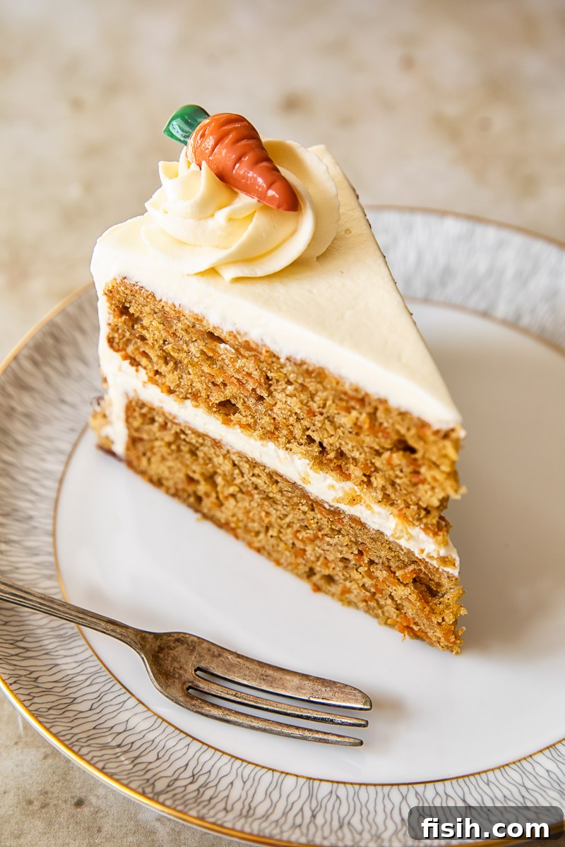Moist Carrot Cake with Tangy Cream Cheese Frosting 3 A perfect slice of moist carrot cake with a generous swirl of cream cheese frosting on a white plate.