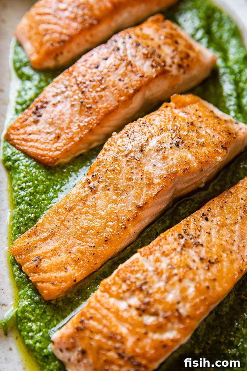 Pan-fried salmon fillet served on a bed of vibrant green basil pesto