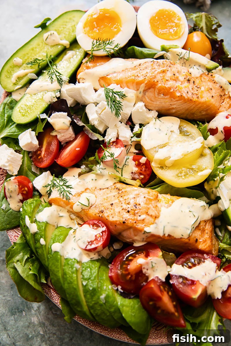 Artisan Salmon Cobb with Zesty Lemon-Dill Dressing 2 A stunning top-down view of a vibrant Salmon Cobb Salad, featuring flaky salmon, creamy avocado, perfectly boiled eggs, crisp greens, and a luscious lemon dill dressing drizzled generously.