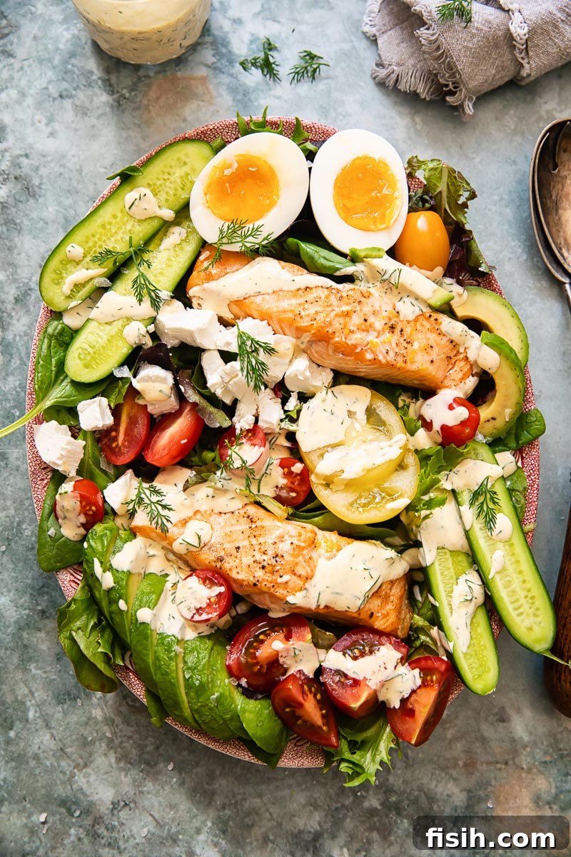 Artisan Salmon Cobb with Zesty Lemon-Dill Dressing 5 An appetizing top-down shot of the fully assembled Salmon Cobb Salad, elegantly arranged on a platter with generous portions of salmon, fresh vegetables, and creamy dressing.