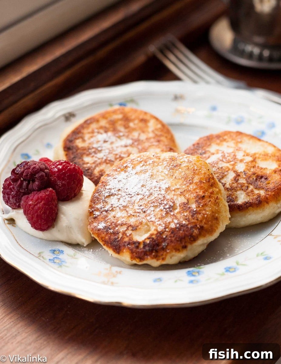 Syrniki: Russian Sweet Cheese Pancakes 5 Stacked Russian curd cheese pancakes Syrniki topped with fresh berries