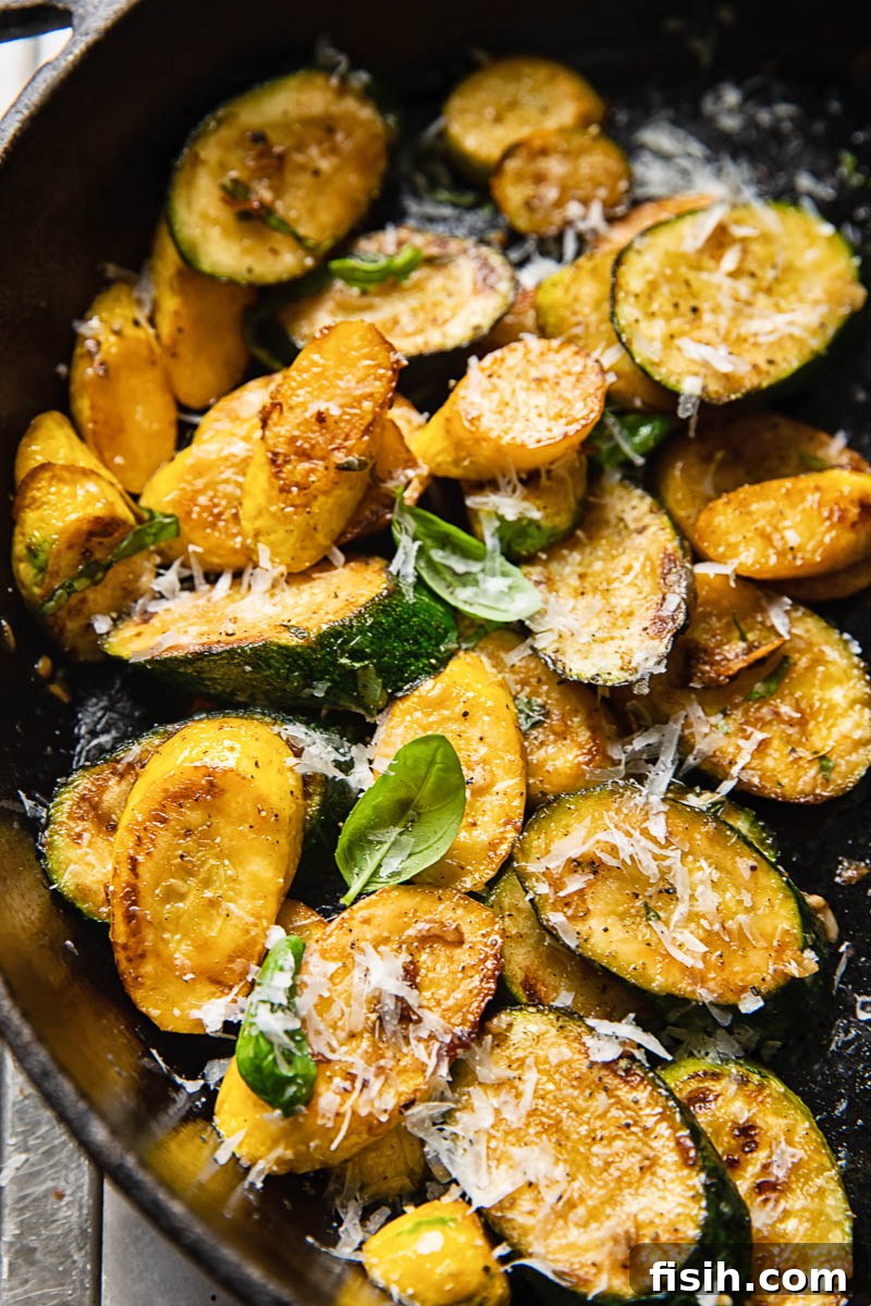 Golden Zucchini with Basil and Pecorino 2 Close-up of golden brown pan-fried zucchini slices, garnished with fresh herbs.