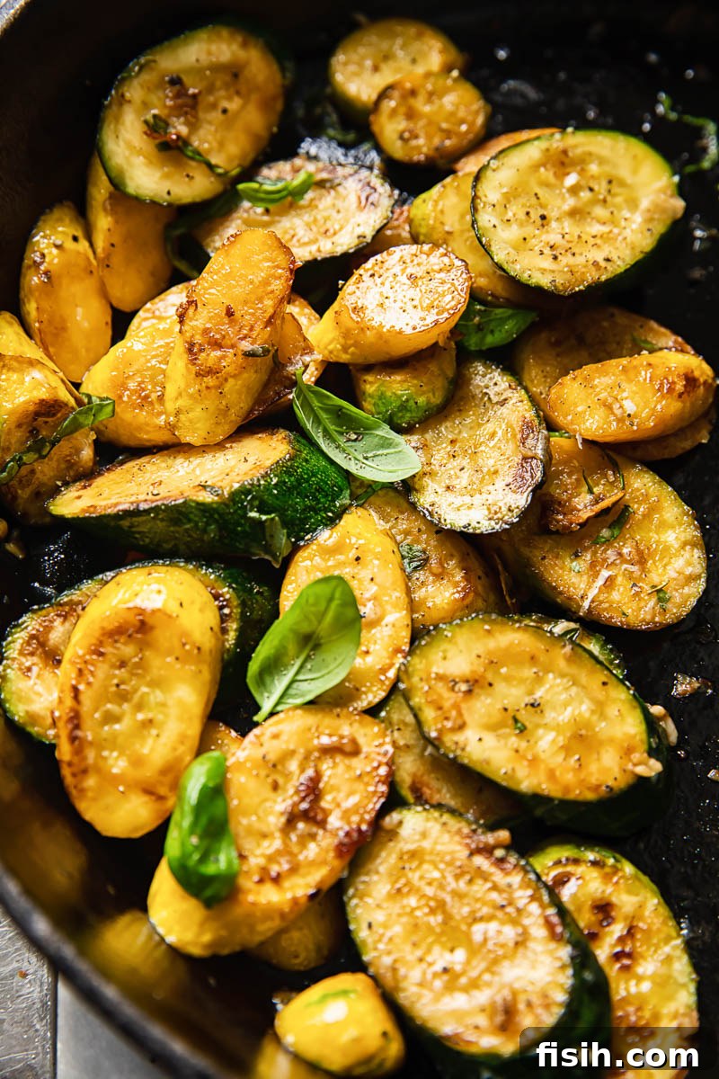 Golden Zucchini with Basil and Pecorino 5 Close-up of cooked zucchini rounds garnished with fresh basil, showcasing a beautiful golden sear.