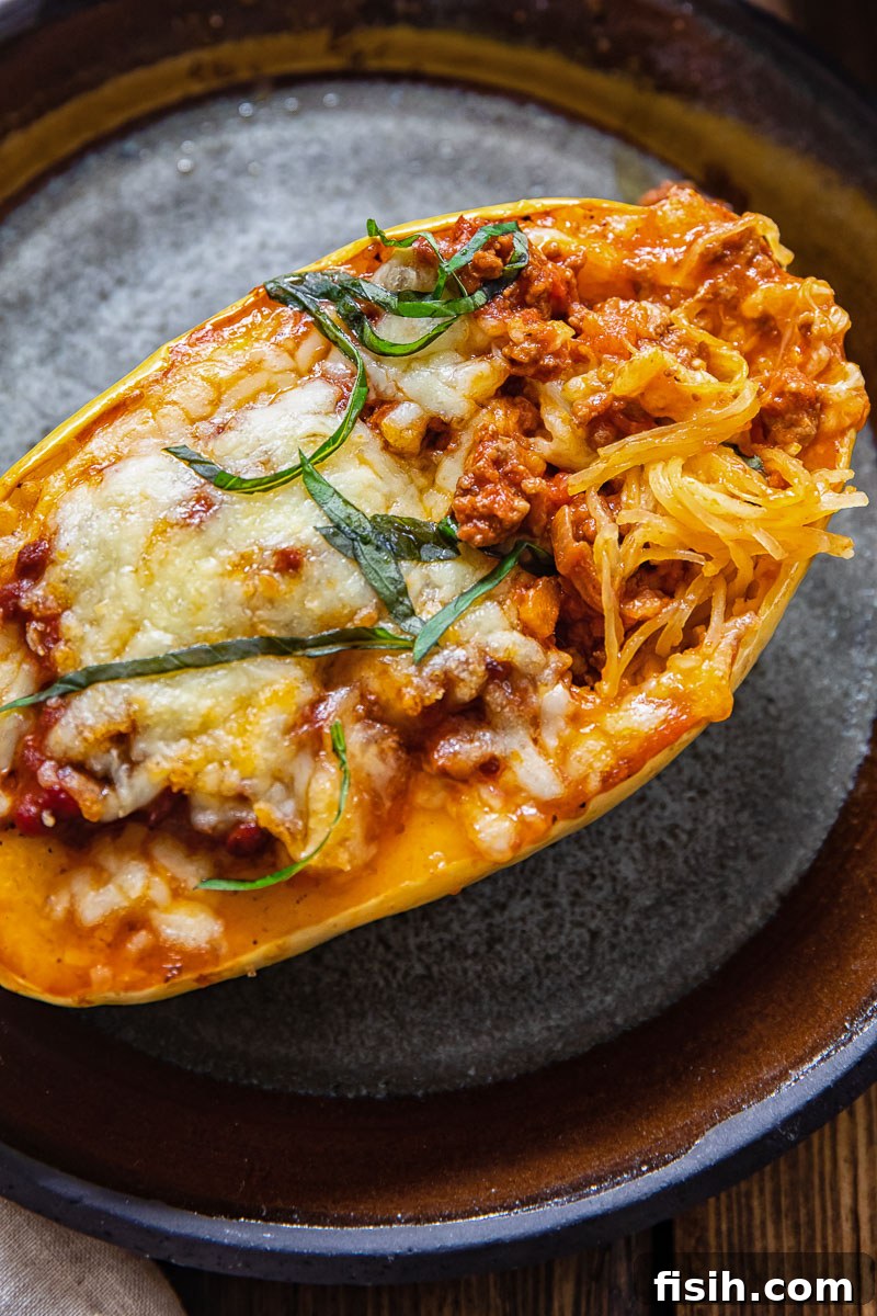 Close-up view of roasted spaghetti squash strands on a plate, showcasing its pasta-like texture, ready to be tossed with sauce.