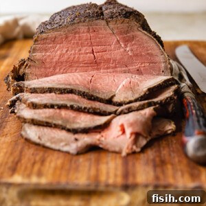 slices of roast beef and whole beef jointon cutting board