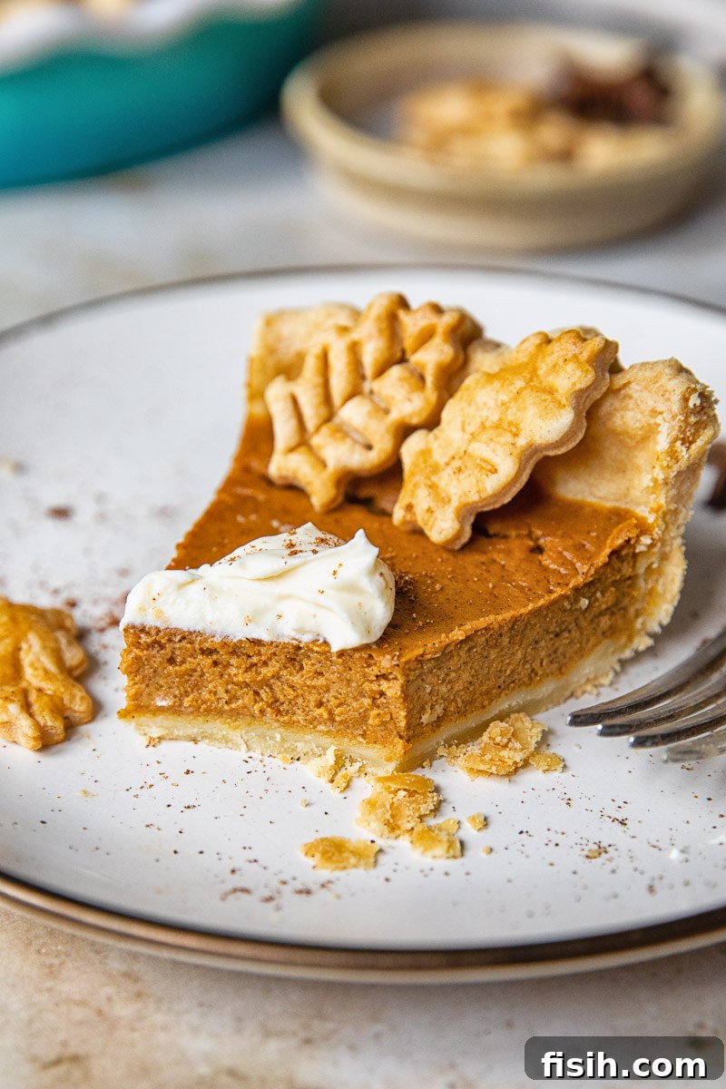 a slice of pumpkin pie on a plate with a bite taken out