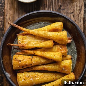 Caramelized Honey Garlic Parsnips 6 top down view of roasted parsnips on a plate on wooden background