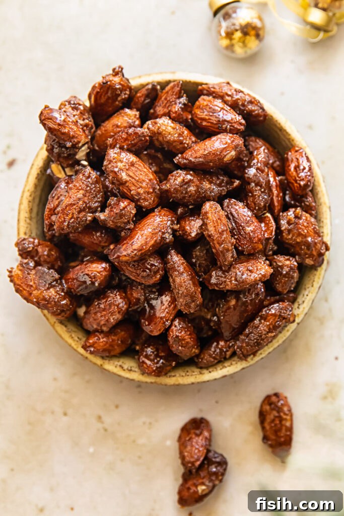 Close-up of a serving dish filled with glistening cinnamon candied almonds, showcasing their crunchy texture and sweet coating.