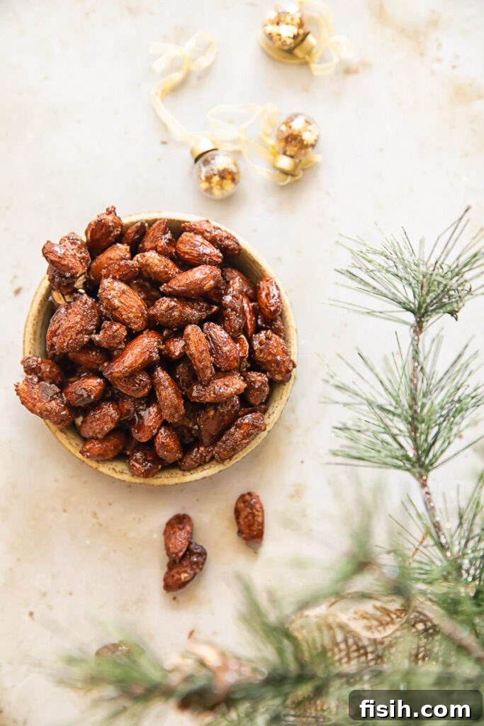 Small elegant serving dish brimming with homemade cinnamon candied almonds, highlighting their golden brown color and inviting texture.