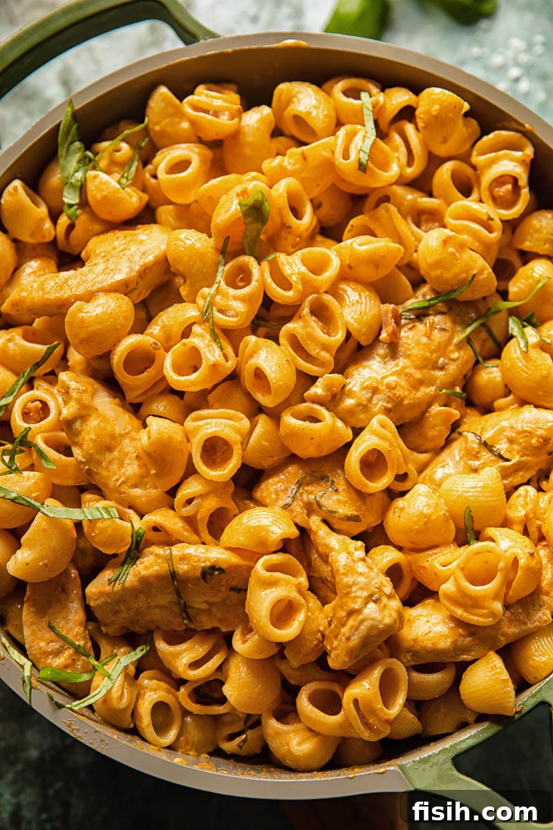 Creamy sun-dried tomato and chicken pasta dish with fresh basil