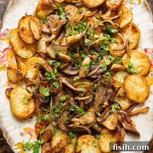 top down view of fried potatoes and mushrooms topped with herbs