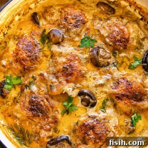 top down view of chicken and mushrooms in a creamy sauce in a round pan
