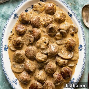 top down view of meatballs in a creamy sauce on a white and blue platter