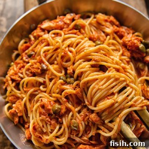 Top-down view of spaghetti in red sauce in a pan