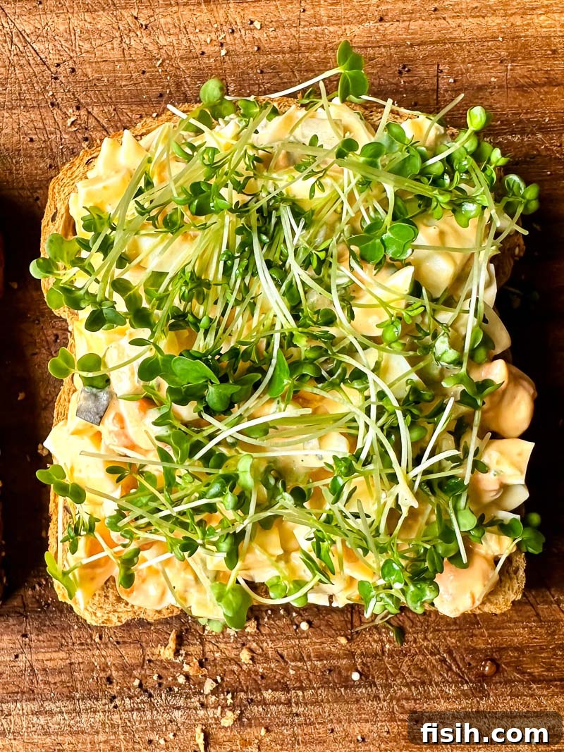 Top down view of creamy egg salad with salad cress on a slice of bread
