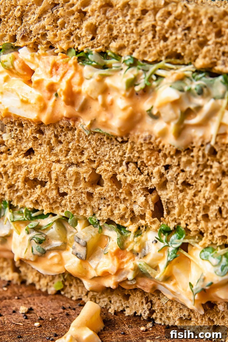 Close-up of a creamy egg mayonnaise sandwich, neatly cut in half, ready to enjoy.