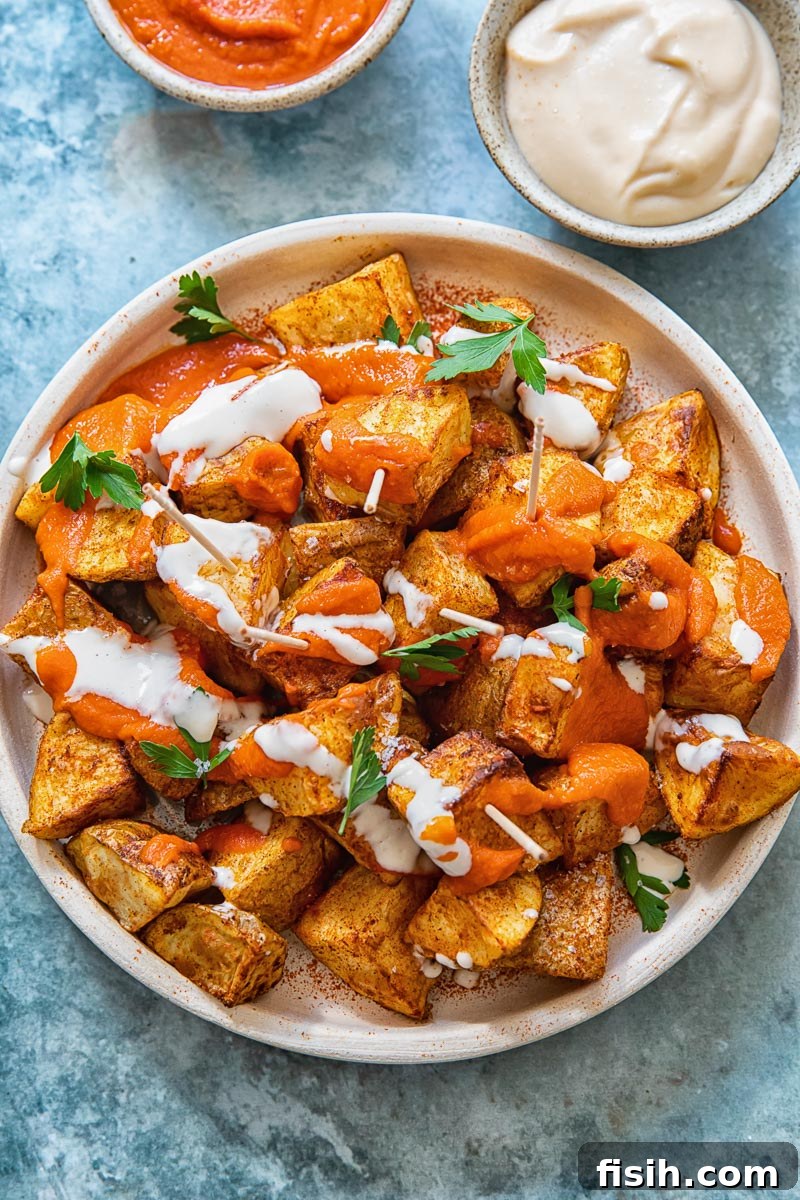top down view of patatas bravas with the red sauce and alioli