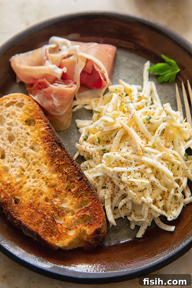 top down view of brown plate with celeriac remoulade, toasted bread slice and Parma ham slice
