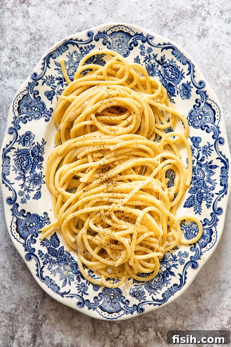 bucatini cacio e pepe on a blue and white oval platter