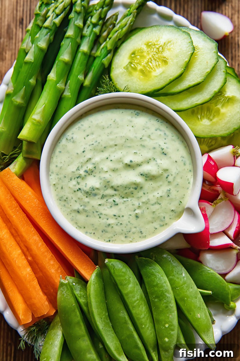 An artful arrangement of crisp, colorful vegetables surrounding a bowl of vibrant green dip, ready for dipping.