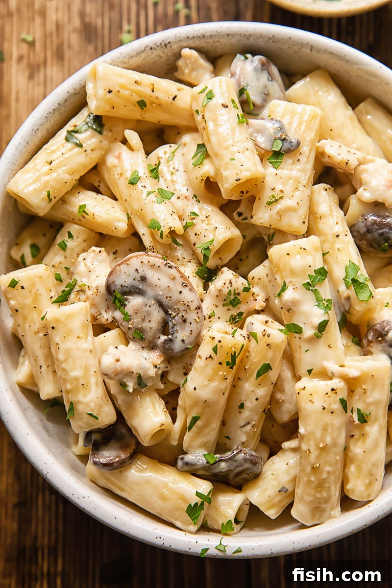 creamy pasta with mushrooms and sausage in a bowl