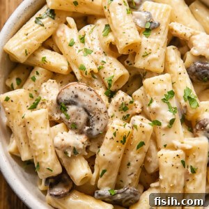 creamy pasta with mushrooms and sausage in a bowl