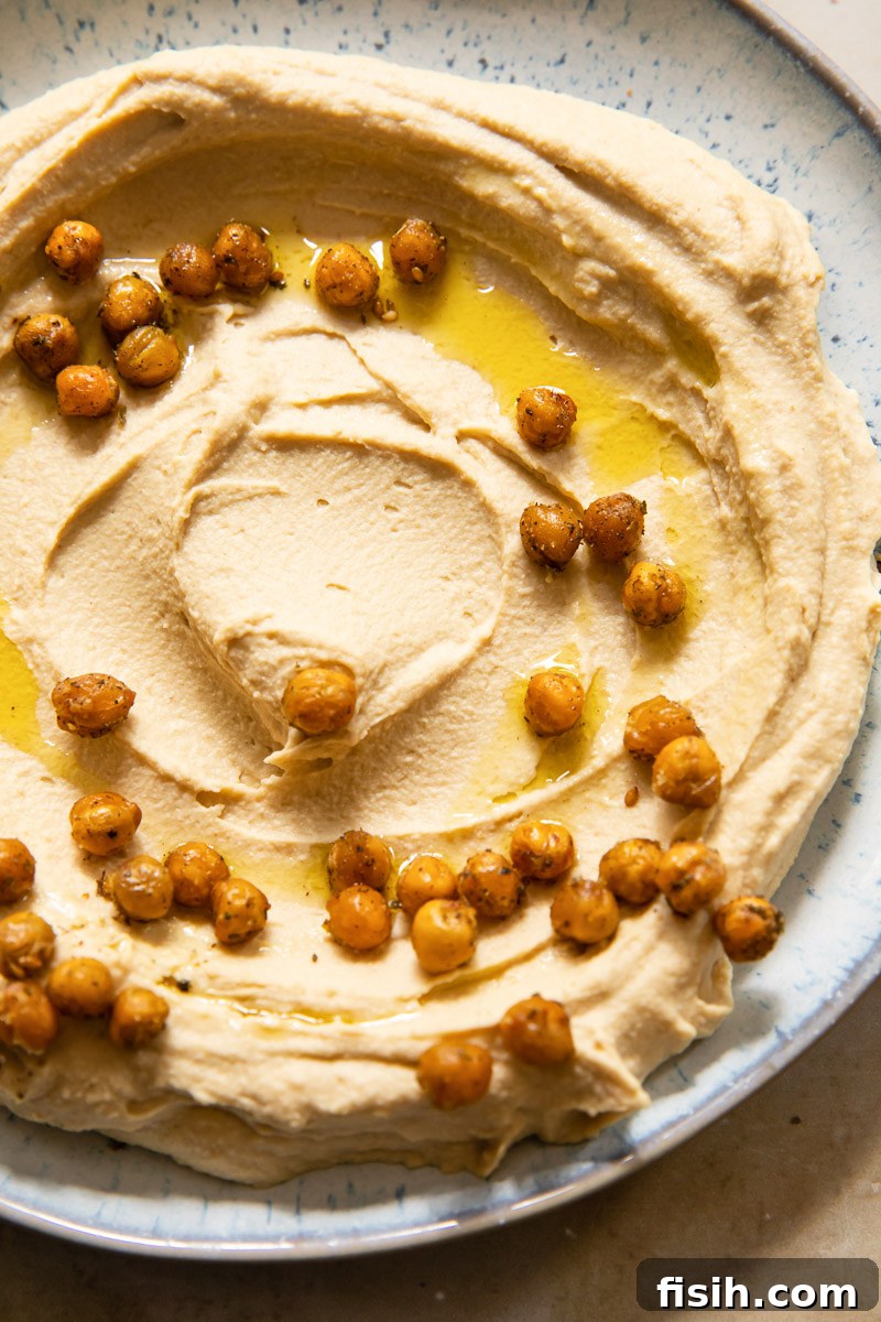 Silky Hummus with Golden Za'atar Chickpea Crunch 2 top down view of hummus topped with roasted chickpeas and olive oil
