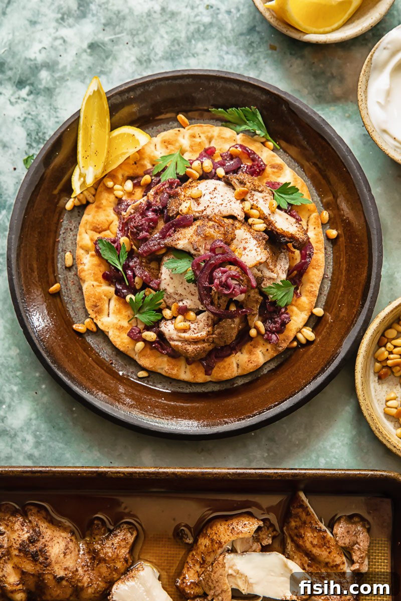 Top down view of Chicken Musakhan on flat bread with roasted chicken in pan, showing ingredients before assembly.