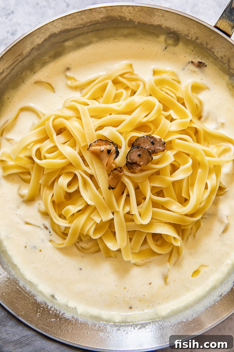 Creamy Truffle Tagliatelle 4 Process shot of tagliatelle pasta being added to truffle sauce in pan