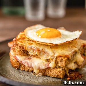 Side view of croque madame sandwich with egg on top on a plate